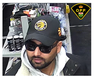 Man wearing a black Toronto Raptors baseball cap and sunglasses