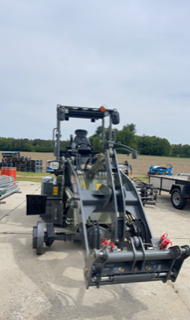 Gray skid steer with bucket.