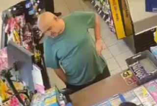 Man in a green shirt looking at lottery tickets