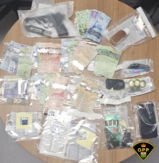 Canadian currency and small baggies on a wooden surface.