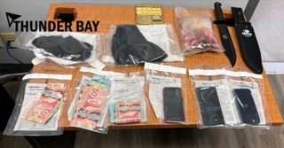 Bundles of cash and baggies on a surface.