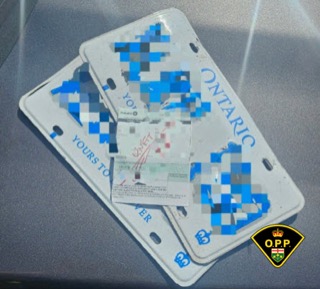 Stacked Ontario license plates, partially obscured