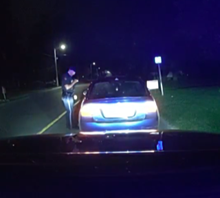 Police officer speaking to driver during a traffic stop.