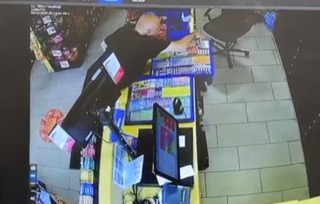 Person reaching for a product on a store shelf.