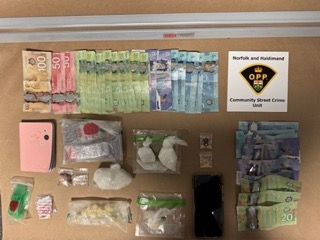 Canadian currency and small baggies on a wooden surface.