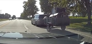 Black SUV towing a utility trailer with equipment.