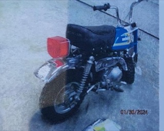 Small dirt bike, yellow seat, black frame, red taillight