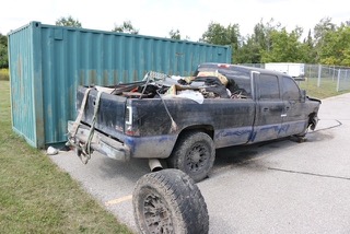 Blue pickup truck with a tire mounted on a rack.
