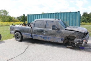 Damaged black pickup truck with blue accents