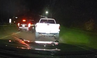White pickup truck, red taillights, wet pavement
