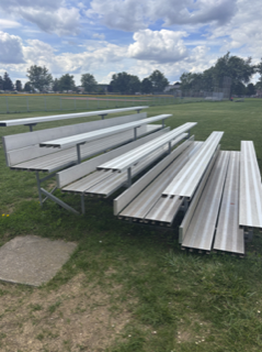 Silver bleachers on green grass.