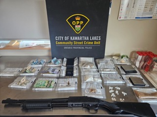 Firearm, cash, and pills on a table.