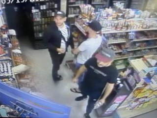 Three men walking in a convenience store.