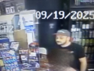 Man wearing a black baseball cap and black t-shirt.