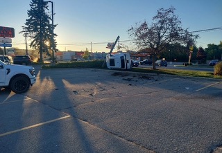 Damaged RV on its side in a parking lot