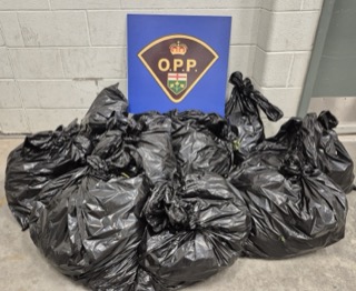 Pile of black garbage bags, Ontario Provincial Police logo