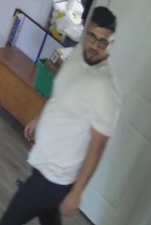 Man in a white t-shirt and black pants, wearing glasses