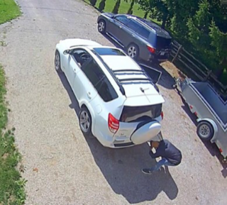 White SUV with a jet ski on a trailer.
