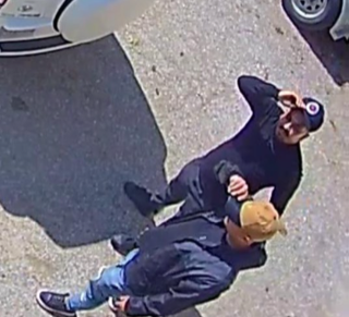 Two people wrestling on pavement