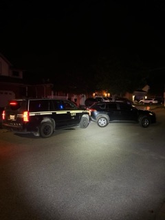 Police SUVs parked on a residential street at night