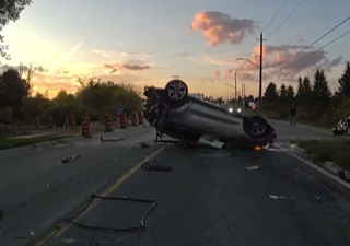 Car overturned on a road, sunset in background