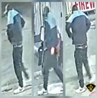 Person walking away, wearing dark clothing and a light-colored hoodie.