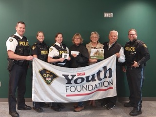 Six people holding a banner that reads "OPP Youth Foundation."