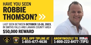 Missing person poster. Robbie Thomson, last seen October 12-18, 2023, in Smiths Falls and Lanark County area. $50,000 reward. Call OPP tipline at 1-855-677-4636 or anonymously to Crime Stoppers at 1-800-222-8477 (TIPS). Man with short brown hair, beard, and glasses.