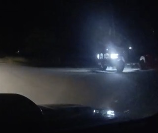Pickup truck headlights illuminate a dark road