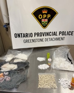 Packages of drugs and pills on a table. Ontario Provincial Police, Greenstone Detachment.