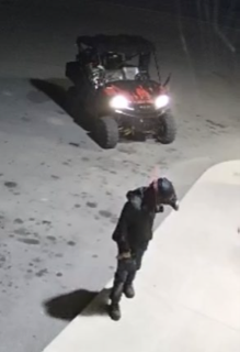 Person jumping over snowbank, ATV in background