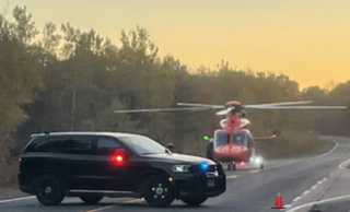Police car with lights on, helicopter in background