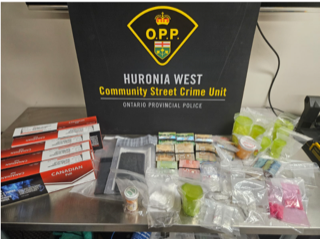 Packages of cigarettes and Canadian money on a metal surface.