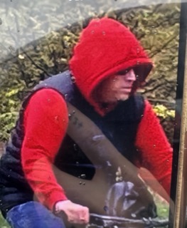 Person wearing a red hoodie and black shirt, looking down