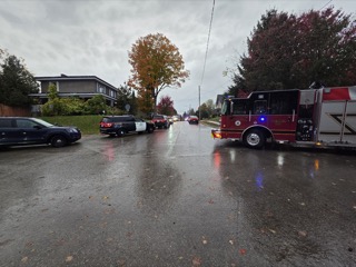 Fire truck and police vehicles on a wet street.