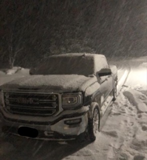 Pickup truck covered in snow.