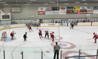 Hockey players in red jerseys facing off on a white ice rink