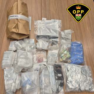Multiple bags of suspected drugs and cash, labeled with police seals.