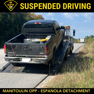 Black pickup truck on a flatbed tow truck.