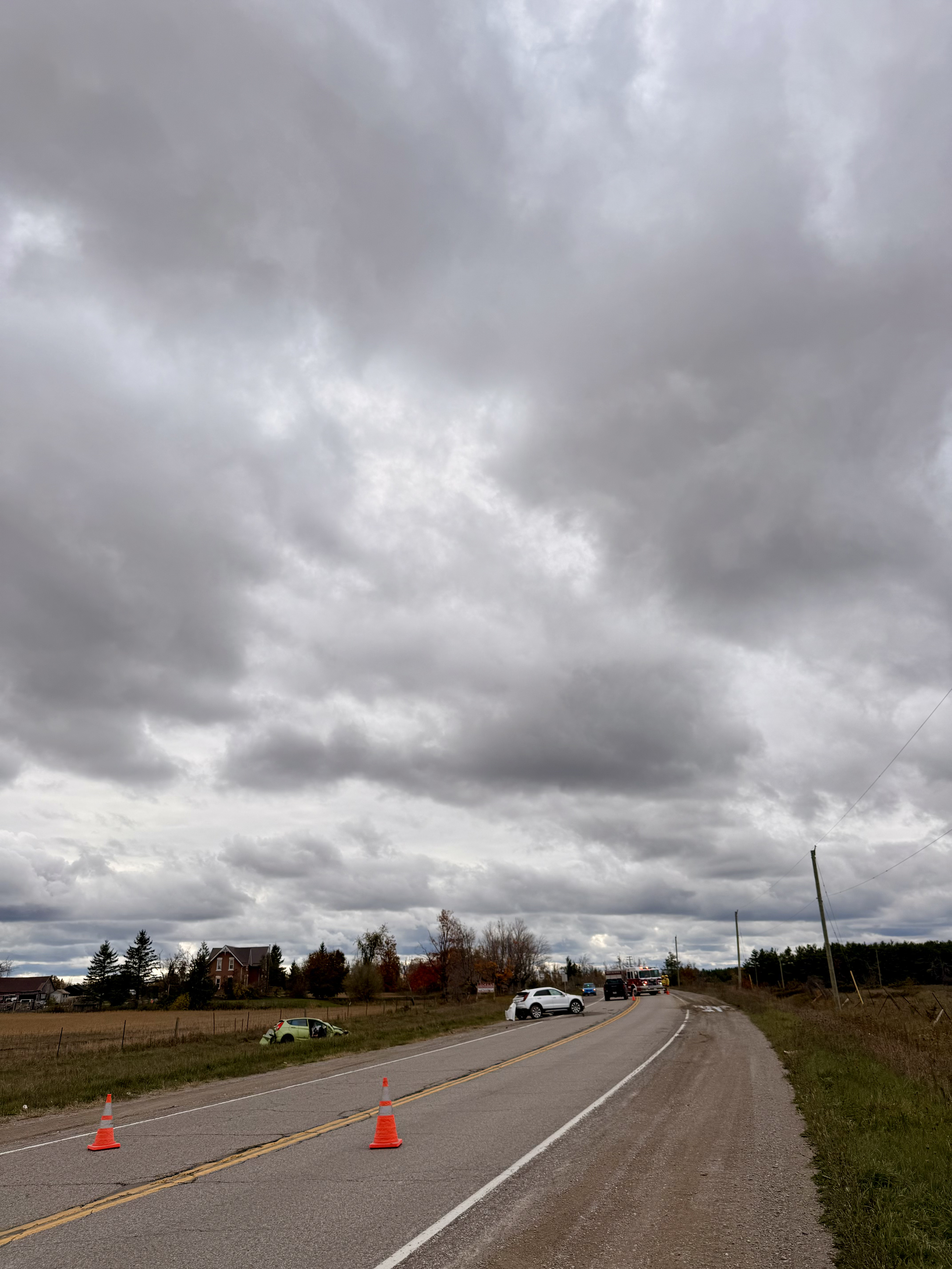 Gray sky over a two-lane road with orange traffic cones.