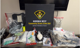 Huron West Community Street Crime Unit, Ontario Provincial Police. Assorted bagged substances and Canadian currency on a metal surface.