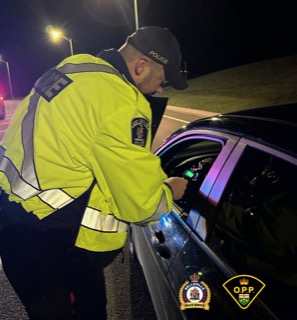 Police officer examining a vehicle's dashboard.