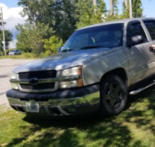 Gray Chevrolet Tahoe parked on grass.