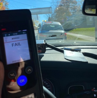 Dashboard view, speed 65 mph, device displaying FAIL