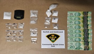 Small baggies of white powder, digital scale, Canadian twenty-dollar bills stacked neatly