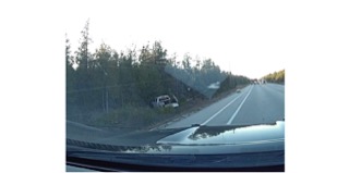 Road curving through a forest, vehicle off the shoulder