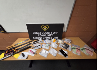 Essex County OPP Community Street Crimes Unit. Numerous bagged items and weapons on a table.
