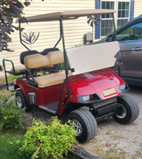 Red golf cart with tan seating