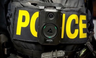 Police uniform with body camera attached.