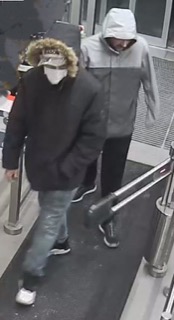 Two people walking through a doorway.